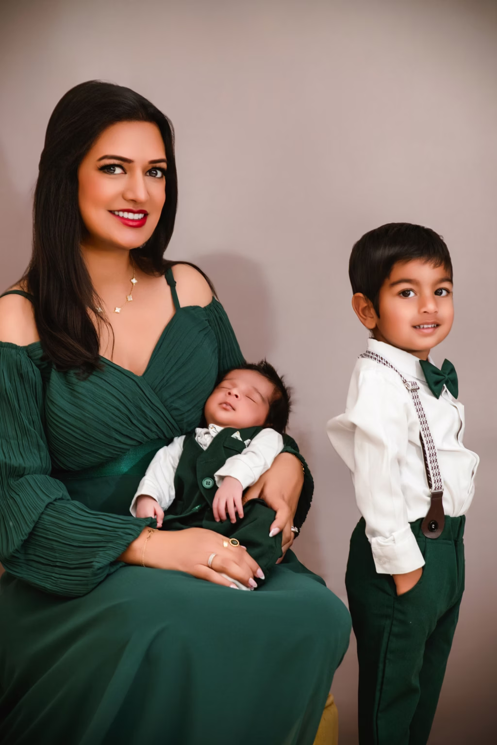 Of mother with newborn and older son in dark green and white - studio photography family