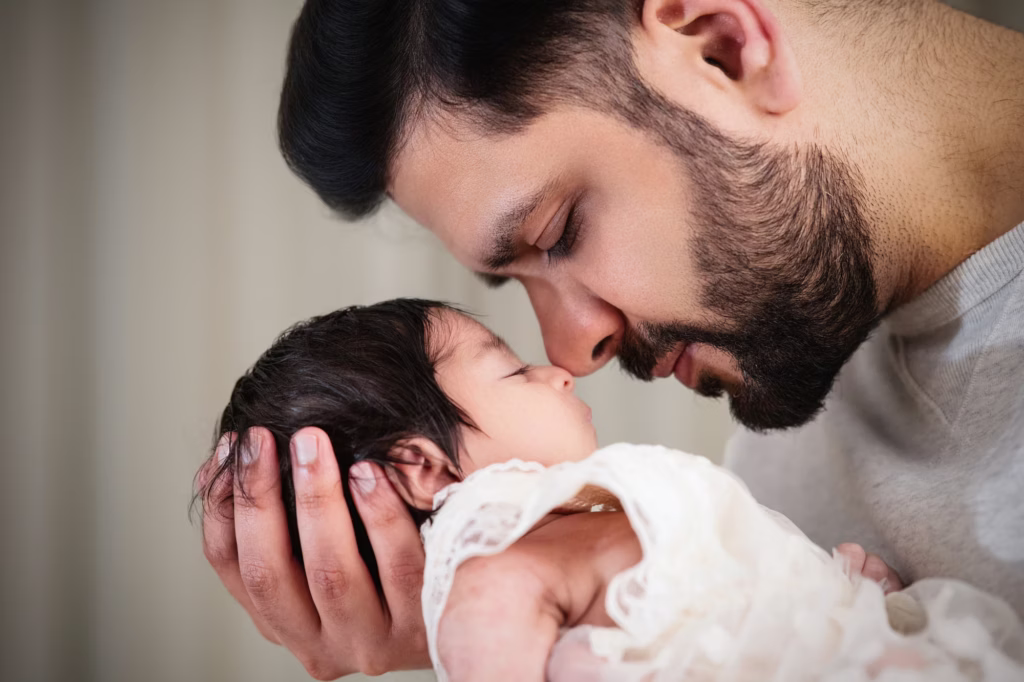 Tender close-up of father holding newborn, noses gently touching with eyes closed, baby in delicate white lace outfit capturing deep peace and connection - new born photos, father baby noses touching